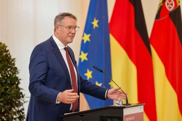 Der rheinland-pfälzische Ministerpräsident Alexander Schweitzer am Rednerpult vor Fahnen in der Staatskanzlei Rheinland-Pfalz. Rede anlässlich der verleihung berufsbezogener Titel des Landes. 03.09.24