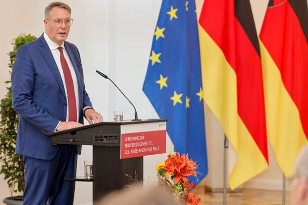 Der rheinland-pfälzische Ministerpräsident Alexander Schweitzer am Rednerpult vor Fahnen in der Staatskanzlei Rheinland-Pfalz. Rede anlässlich der verleihung berufsbezogener Titel des Landes. 03.09.24