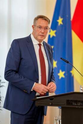 Der rheinland-pfälzische Ministerpräsident Alexander Schweitzer am Rednerpult vor Fahnen in der Staatskanzlei Rheinland-Pfalz. Rede anlässlich der verleihung berufsbezogener Titel des Landes. 03.09.24