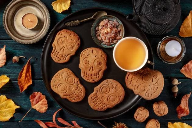 Halloween Ingwerplätzchen in Form von Totenköpfen, hausgemachte Dia de los muertos Kekse, von oben auf einen dunklen Holzhintergrund geschossen Halloween ginger cookies in the shape of skulls, homemade Dia de los muertos biscuits, shot from the top on a dark wooden background Copyright: imageBROKER KaterinaxSolovyeva ibxiqx09657237.jpg