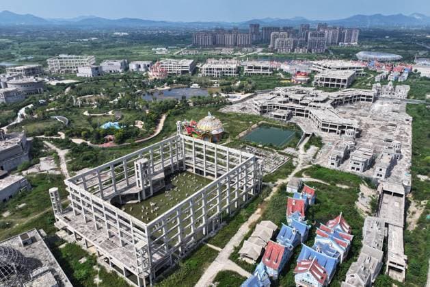 Unfinished Project of Evergrande Cultural Tourism City in Zhenjiang ZHENJIANG, CHINA - SEPTEMBER 5, 2024 - Aerial photo taken on September 5, 2024 shows the unfinished project of Evergrande Cultural Tourism City in Zhenjiang City, Jiangsu province, China. The project created by Evergrande Tourism Group, covers an area of about 1,600 mu, planning to build a world-class fairy tale theme park, and Shanghai Disneyland competition, originally planned to be officially opened in July 2021. Now it s all overgrown and desolate, and only an empty city remains. Zhejiang Jiangsu China  Copyright: xCFOTOx i1725521917039