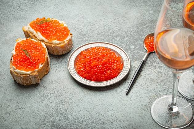Small metal plate with red salmon caviar, two caviar toasts canape, two glasses of champagne top view on grey concrete background, festive luxury delicacy and appetizer Small metal plate with red salmon caviar, two caviar toasts canape, two glasses of champagne top view on grey concrete background, festive luxury delicacy and appetizer. Copyright: xZoonar.com OlenaxYeromenkox 22092847