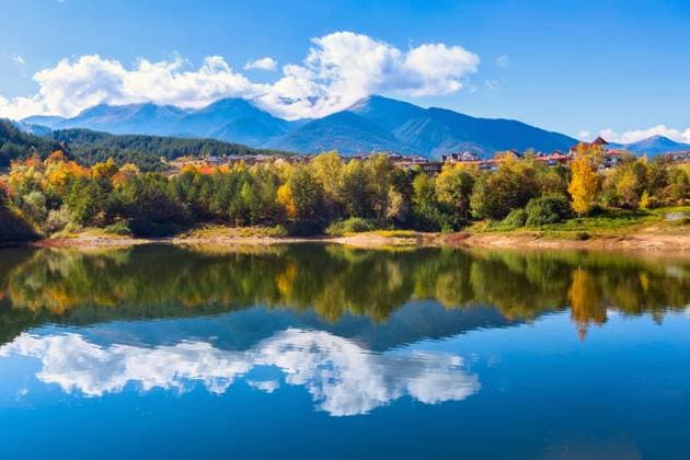 Bansko, Bulgarien Herbstpanorama Hintergrund der Pirin Berggipfel, See Wasser, bunte grüne, rote und gelbe Bäume Reflexion Bansko, Bulgaria autumn panorama background of Pirin mountain peaks, lake water, colorful green, red and yellow trees reflection Copyright: imageBROKER Nataliya_Nazarova{} ibxiqx09687823.jpg