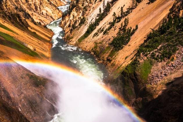 Creative Highlights World Stunning view of a rainbow arching over a canyon and river Yellowstone National Park, Wyoming, United States R_OCZQ240907-1524263-01
