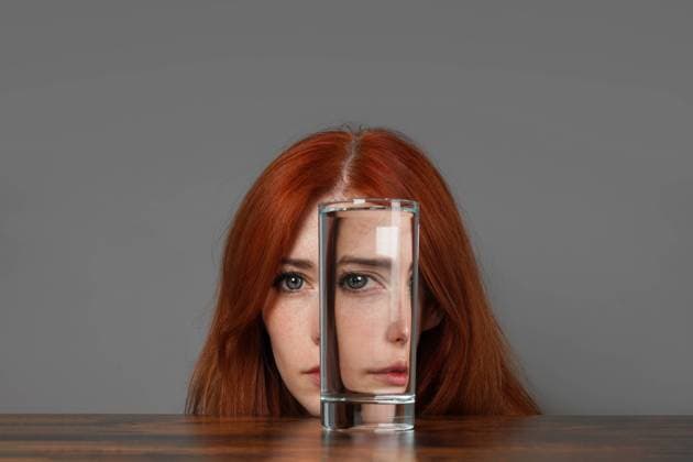 Creative Highlights Symbolfotos Verzerrtes Gesicht einer Frau, die durch ein Wasserglas schaut - Konzept der Introspektion und Dualität mit kreativer Brechung distorted face of woman looking through glass of water - introspection and duality concept with creative refraction Copyright: imageBROKER AxelxBückert ibxiqx08522367.jpg ,model released, Symbolfoto ,property released