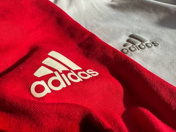 Adidas, Logo, Sportbekleidung, Rot und Weiß, Markenlogo, Sportmode, Athleisure, Design, Textilien, Sportmarke, Fashion, Freizeitkleidung, Trainingsbekleidung, Sportartikelhersteller, Stil, Lifestyle, Markenidentität, Sportindustrie, Fitnessbekleidung, Athletik, Sporttrends, Farben Rot und Weiß, Material, Textur, Stoffe, Markenpräsenz, Modebewusstsein, Sportstyle, Fitness, Freizeit, Adidas Originals, Bekleidungsdetail. Copyright: xJOERANxSTEINSIEKx