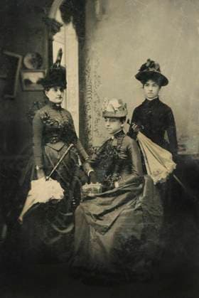 Portrait of Three Adult Women in Hats and Long Dresses with Parasols, One Seated, 1870  Copyright: xABxArchivex jtv007807