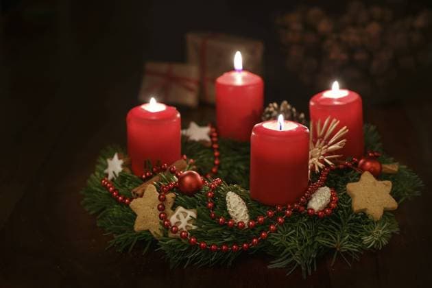 Adventskranz aus Tannenzweigen mit rot leuchtenden Kerzen und Weihnachtsdekoration, einige Geschenke unscharf im dunklen Hintergrund, Kopierraum, gewählter Fokus, geringe Tiefenschärfe Advent wreath from fir branches with red lit candles and Christmas decoration, some gifts blurred in the dark background, copy space, selected focus, narrow depth of field Copyright: imageBROKER MarenxWinter ibxiqx11039315.jpg