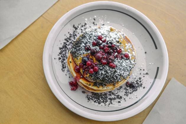 Pfannkuchen mit Erdnussbuttercreme, Beeren, Streuseln und Puderzucker auf einem Teller und einem Holztisch, süßes Brunch oder Dessertgericht, Draufsicht von oben, Kopierraum, gewählter Fokus, enge Tiefenschärfe Pancakes with peanut butter cream, berries, crumble and icing sugar on a plate and a wooden table, sweet brunch or dessert dish, top view from above, copy space, selected focus, narrow depth of field Copyright: imageBROKER MarenxWinter ibxiqx11040469.jpg