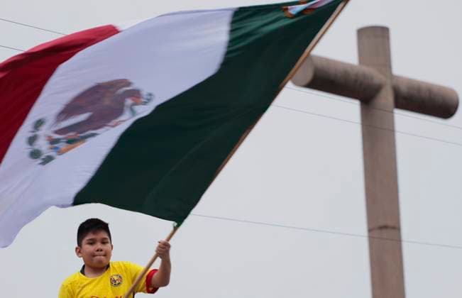 Mexicans And Tourists Get Ready For The Grito De Independencia Of Mexico This September 15 A boy waves a flag next to a cross in Mexico City, Mexico, on September 14, 2024, ahead of the Grito de Independencia de Mexico to be held on September 15 in the capital s Zocalo, led by Mexican President Andres Manuel Lopez Obrador. Mexico City Mexico City Mexico  Copyright: xGerardoxVieyrax originalFilename: vieyra-notitle240914_npREm.jpg