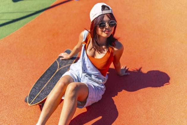 Creative Highlights Symbolfotos Top view of a cool chinese woman sitting next to skateboard in a colorful urban park Copyright: imageBROKER UnaixHuizi ibxuhu10916292.jpg ,model released, Symbolfoto ,property released