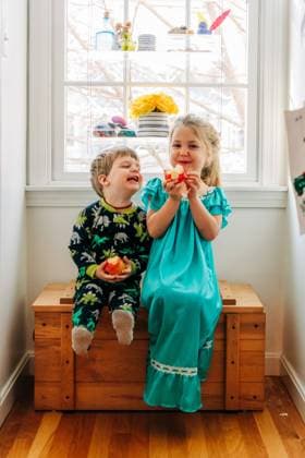 Creative Highlights Symbolfotos Two children sitting together by a window, happily eating apples North Andover, Massachusetts, United States CR_FKNH240911A-1537945-01 ,model released, Symbolfoto