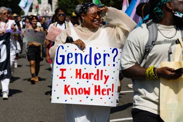 September 14, 2024, Washington, District of Columbia, USA: A woman smiles as she marches, holding a protest sign that reads, Gender? I Hardly Know Her! during the Gender Liberation March 2024 Washington USA - ZUMA 20240914_mda_n315_653 Copyright: xHeidixNaguibx