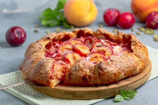 Fruit open pie (galette). Sliced delicious homemade open pie (galette) with red cherry plum, peaches and fragrant cardamom. Selective focus. Copyright: xZoonar.com MarinaxSaprunovax 22179880