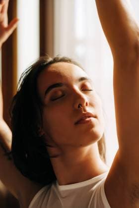 Woman basking in soft sunlight, eyes closed in serene expression Haverhill, Massachusetts, United States CR_FKNH240917-1543093-01 ,model released, Symbolfoto