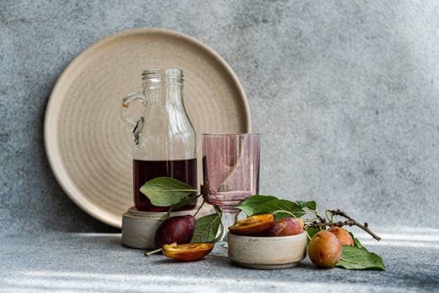 IMAGO Creative, Jahreszeit Sommer, Food, Pflaume Ripe plums and liqueur on concrete table Tbilisi, Tbilisi, Georgia R_LSQHTY2409047F-1532995-01
