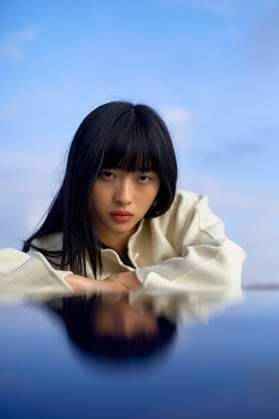 Creative Highlights Symbolfotos Woman with dark hair lying down, her reflection visible on a glossy surface, against a blue sky backdrop. bola03192 Copyright: xConnectxImagesx ,model released
