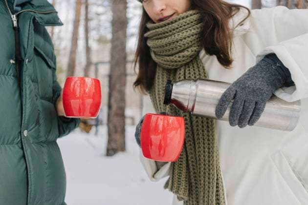 Woman in warm clothes pouring coffee in cups model released, Symbolfoto property released, SEAF02284