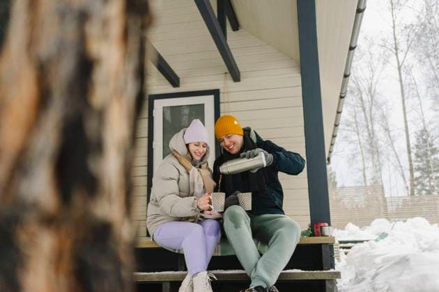 Smiling man serving hot coffee to woman sitting on porch model released, Symbolfoto property released, SEAF02306