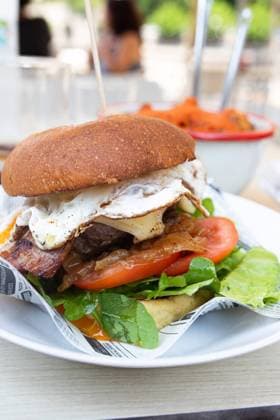 A delicious gourmet burger featuring a succulent beef patty topped with crispy bacon, a perfectly fried egg, fresh lettuce, ripe tomato slices, and vibrant greens, served on a toasted bun Model Released Gaorstudio_ID23796_690703_003 Copyright: xGaorstudiox RECORD DATE NOT STATED