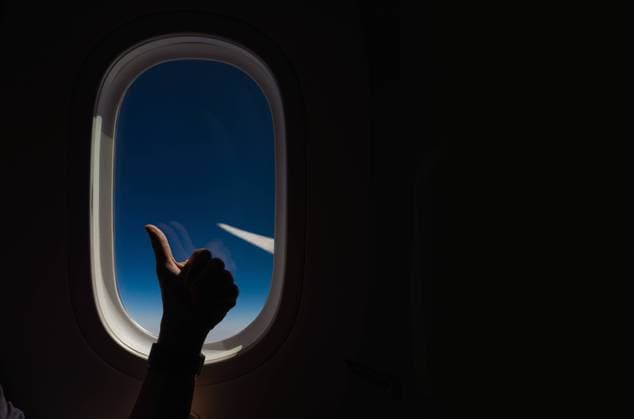 Creative Highlights Symbolfotos Cropped unrecognizable passenger s hand framing the view of the sky and airplane wing, as seen through the aircraft s window, capturing the essence of flight and travel. Model Released Javigu_ID23898_693434_006 Copyright: xJavigux RECORD DATE NOT STATED