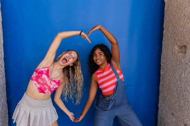 Creative Highlights Symbolfotos A joyful multiracial lesbian couple forms a heart with their arms against a vibrant blue background, representing love and LGBTQIA+ pride Model Released JoseCarlosIchiro_ID23778_690220_082 Copyright: xJosexCarlosxIchirox