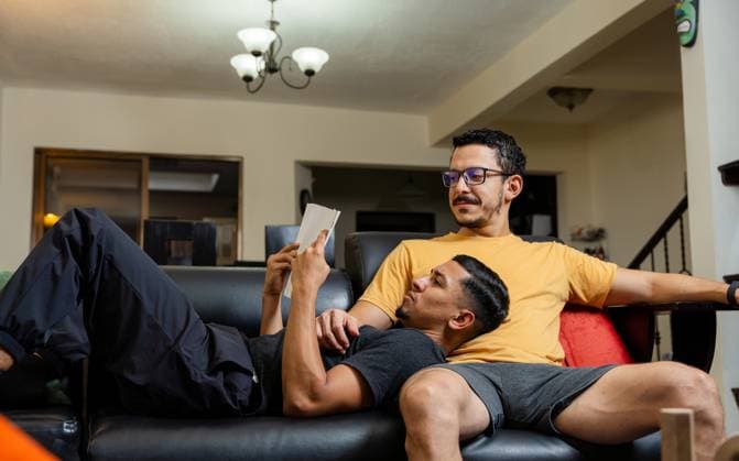 A loving gay couple shares a quiet and cozy moment in their living room, showcasing the deep connection and comfort within their relationship This scene highlights the warmth and affection characteristic of LGBTQIA+ relationships Model Released LeoTenorio_ID23718_688322_011 Copyright: xLeoxTenoriox RECORD DATE NOT STATED