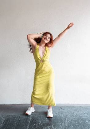 Creative Highlights Symbolfotos A young woman in a vibrant yellow dress dances joyfully while listening to music on her headphones, expressing freedom and happiness. Model Released ManuelRuiz_ID24145_699875_028 Copyright: xManuelxRuizx