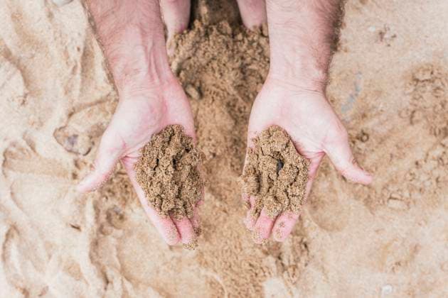 Creative Highlights Symbolfotos From above close-up image of cropped unrecognizable male two hands cupped and holding sand. Model Released PaulaBerezo_ID23614_685712_001 Copyright: xPaulaxBerezox