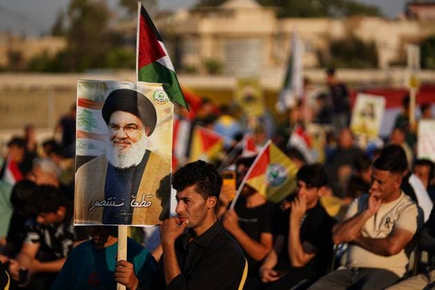 Solidarity stand in Mosul, Iraq against the Israeli aggression on Palestine and Lebanon - 27 Sept 2024 Supporter of Kataeb Sayyid al-Shuhada armed faction (member of the Hashed al-Shaabi Popular Mobilisation Forces or PMF) hold a portrait of Hezbollah chief Hassan Nasrallah during a solidarity stand against the Israeli aggression on Lebanon and Palestine near the Great Mosque (not in view) of Mosul in the city of Mosul. Mosul Iraq Copyright: xIsmaelxAdnanx xSOPAxImagesx IADNAN_01853