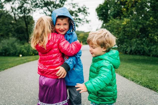 Creative Highlights Symbolfotos Three children hugging outdoors, dressed in bright jackets North Andover, Massachusetts, United States CR_FKNH240904A-1527052-01 ,model released, Symbolfoto