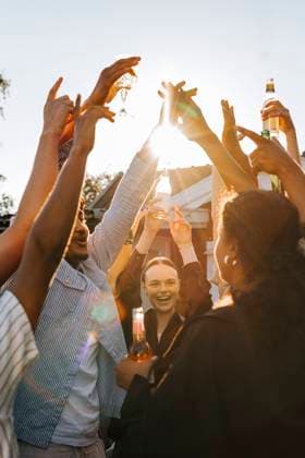 IMAGO Creative, Lifestyle, Feste im Garten #2 Multiracial group of male and female friends with hands raised enjoying in back yard on sunny day at social party Sweden, Stockholm, model released, property released Copyright: xMaskotx, MA112399