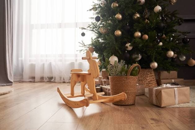 View of wooden rocking rabbit in the center of living room with decorated christmas tree, wicker basket with spruce branches, gifts in craft paper with copy space View of wooden rocking rabbit in the center of living room with decorated christmas tree, wicker basket with spruce branches, gifts in craft paper with copy space. Copyright: xZoonar.com DARYAxKOMAROVAx 22060138