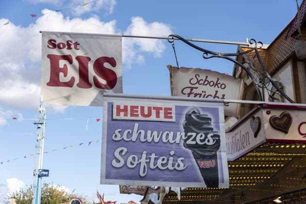 Werbeschild für schwarzes Softeis auf einem Rummel mit blauem Himmel im Hintergrund, Magdeburg, Sachsen-Anhalt, Deutschland, Europa Advertising sign for black soft ice cream on a fairground with blue sky in the background, Magdeburg, Saxony-Anhalt, Germany, Europe Copyright: imageBROKER StephanxSchulz iblsns11490019.jpg