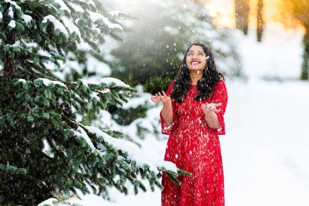 Woman in red lace dress enjoys snowfall near snow-covered pine trees. Placerville, California, United States R_OCZQ241001E2-1546489-01 ,model released, Symbolfoto