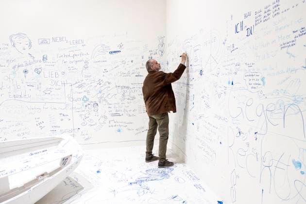 Einzelausstellung Music of the Mind von Yoko Ono in Düsseldorf. Add Colour - Refugee Boat ( Füge Farbe hinzu - Füchtlingsboot ), ein Holzboot, weiß angestrichen, wie auch der gesamte Raum weiß angestrichen ist. Jeder kann etwas beitragen. Es wird darauf hingewiesen, dass in diesem Raum zu Aufzeichnungszwecken gefilmt wird. Jeder Besucher kann irgendetwas Sinnhaftes oder auch Sinnloses mit Filzstift vermerken. Im Übrigen bezeichnen K20 und K21 der Stiftung Kunstsammlung Nordrhein-Westfalen in Düsseldorf Kunst des 20. und des 21. Jahrhunderts. Bei Yoko Ono ist s beides. Düsseldorf Nordrhein-Westfalen Deutschland