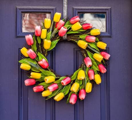 Wreath of silk tulips on front door as sign of springtime Arrangement of tulips in circular wreath on exterior door marking the start of Easter and springtime Copyright: xZoonar.com StevenxHeapx 21552861