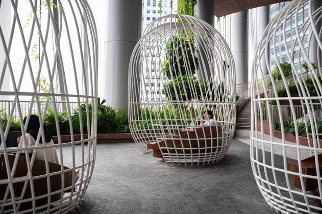 01.08.2023, Singapur, Republik Singapur, Asien - Personen sitzen an Tischen in vogelkaefig-artigen Sitzbereichen auf einer von vier Ebenen des vertikalen Gartens Green Oasis im neuen CapitaSpring Wolkenkratzer im zentralen Geschaeftszentrum am Raffles Place. Das Gebaeude wurde vom daenischen Architekturbuero Bjarke Ingels Group (BIG) entworfen.
