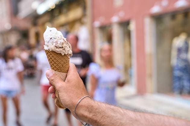 IMAGO Creative, Jahreszeit Sommer, Hitze Corfu, Greece - September 4, 2024: A hand holds an ice cream in a waffle *** Eine Hand hält ein Eis in einer Waffel