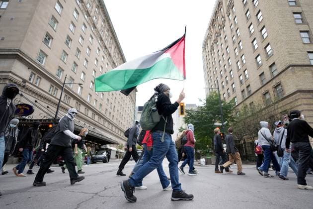 October 7, 2024, Montreal, Pq, CANADA: An attendee marches with a Palestinian flag during a pro-Palestinian demonstration on the anniversary of a Hamas attack on Israel that triggered the ongoing war in Gaza, in Montreal, Monday, Oct. 7, 2024. Montreal CANADA  - ZUMAc35_ 20241007_zaf_c35_058 Copyright: xChristinnexMuschix
