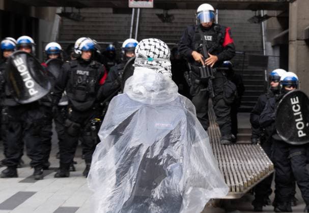 October 7, 2024, Montreal, Pq, CANADA: A Palestinian supporter stands in front of police as they march onto campus on the anniversary of a Hamas attack on Israel that triggered the ongoing war in Gaza, in Montreal, Monday, Oct. 7, 2024. Montreal CANADA  - ZUMAc35_ 20241007_zaf_c35_081 Copyright: xChristinnexMuschix