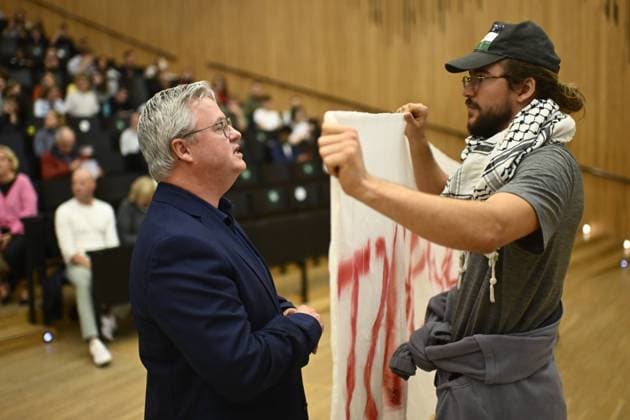 Bilder des Jahres 2024, News 10 Oktober News Themen der Woche KW41 News Bilder des Tages Belgien, Pro-Palästina-Protest an der Universität Gent Professor Carl Devos and a protesters pictured during the opening lecture of the Political Sciences course of professor Devos by MR chairman Bouchez at the political faculty of the UGent university in Gent, Tuesday 08 October 2024. As is his annual custom, Professor C. Devos will host a political leader for the opening Political Science lecture.  DIRKxWAEM 102140282