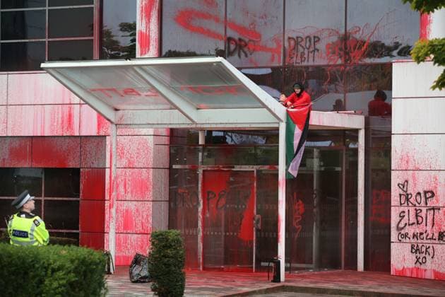 News Themen der Woche KW41 News Bilder des Tages Großbritannien, Farbanschlag von von Pro-Palästina-Aktivisten auf Allianz Zentrale in Guildford October 8, 2024, Guildford, England, UK: Activists sit down as they occupy the roof over the main entrance after covering the entrance with paint watched by a police officer. Palestine Action target Allianz insurance offices branches around the UK, smashing their windows, spraying the outside of their branches with paint and daubing graffiti on the buildings. Palestine action are targeting Allianz because they insure and invest in Israeli arms company Elbit Systems, They demand the company drops Elbit Systems. Guildford UK - ZUMAmp3_ 20241008_zip_mp3_022 Copyright: xMartinxPopex