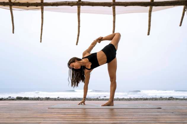 Creative Highlights Symbolfotos A woman strikes a Natarajasana pose (Dancer s Pose) on a wooden deck overlooking the ocean in Mizata, La Libertad, El Salvador. Looking away and focused, she demonstrates the beauty of yoga against a serene beach backdrop. Model Released Almuzambrana_ID23828_691732_017 Copyright: xAlmuzambranax