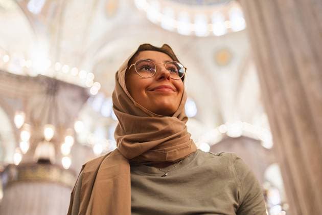 Creative Highlights Symbolfotos From below inside Istanbul s Blue Mosque, a young woman clad in a beige hijab looks up, her eyes filled with joy and wonder, showcasing the stunning architecture above. Model Released DavidMunoz_ID24078_697510_008 Copyright: xDavidxMunozx