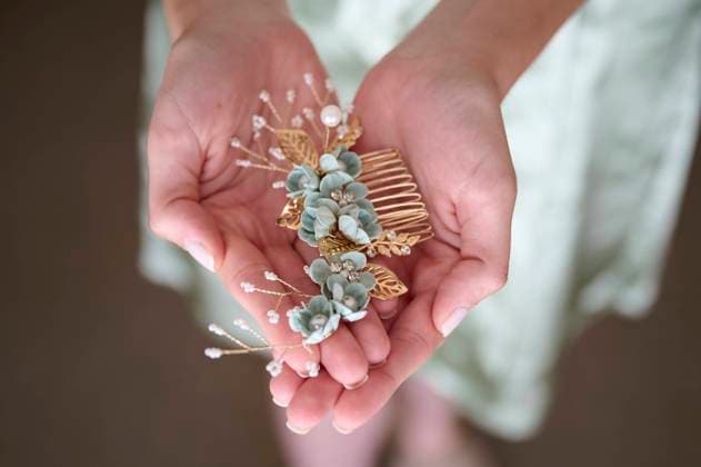Creative Highlights Symbolfotos A close-up image showing a bride holding a delicate floral hair accessory with gold accents and subtle hues, symbolizing the elegant details of a wedding Model Released GermanLinares_ID24218_702002_004 Copyright: xGermanxLinaresx