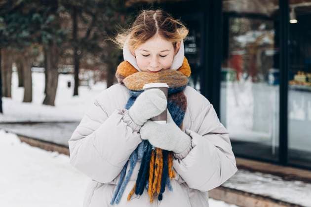 A teenage girl in a winter setting, warmly clad and holding a hot beverage, savors the warmth as snow blankets the surroundings Model Released HannaYakimenko_ID24170_700572_005 Copyright: xHannaxYakimenkox