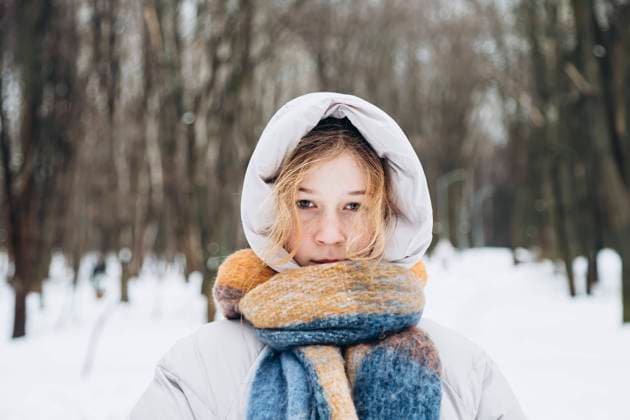 Creative Highlights Symbolfotos A young teenage girl wrapped warmly in a hooded coat and colorful scarf stands amidst a snowy forest, portraying a serene and contemplative mood Model Released HannaYakimenko_ID24170_700578_010 Copyright: xHannaxYakimenkox