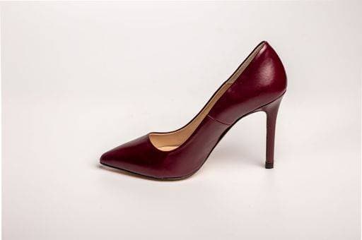 A close-up of a single burgundy high-heeled shoe against a white background 25789657 RECORD DATE NOT STATED