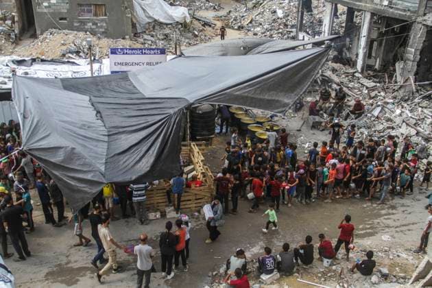 News Themen der Woche KW41 News Bilder des Tages October 9, 2024, Gaza City, The Gaza Strip, Palestine: Palestinians line up at a charity restaurant to distribute food Palestinians walk through rubble in the northern Gaza Strip. Gaza City Palestine - ZUMAq100 20241009_zaa_q100_028 Copyright: xMahmoudxIssax